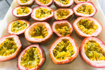 Obraz na płótnie Canvas Half cut passion fruits on white plate. Ripe passion fruit isolated on table.