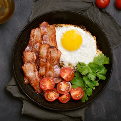 Fried egg with bacon and fresh tomatoes