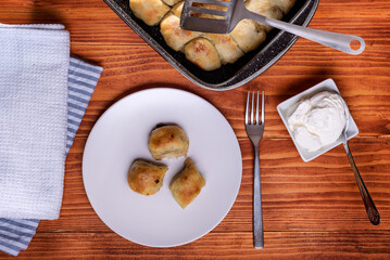 Mantije ( manti ) - Balkan cuisine filled pastry on a rustic table served with creme fraiche or yogurt, popular and traditional national dish. Ususally staffed with meet or cheese. Top View