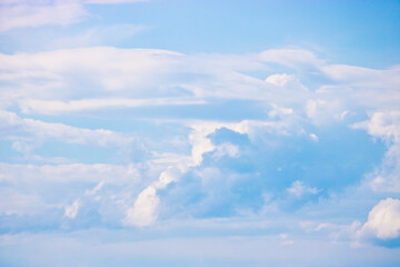 Cumulus and cirrus clouds in the blue sky. Atmospheric phenomenon, weather, summer.