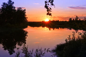 Colorful sunset over the river. Calm summer landscape.