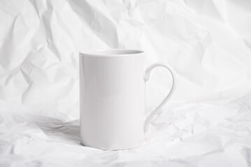 Obraz na płótnie Canvas White Porcelain coffee mug, cup on crumpled background