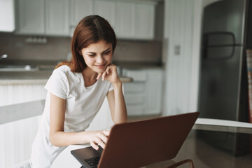 Woman in front of laptop at home communicating internet 