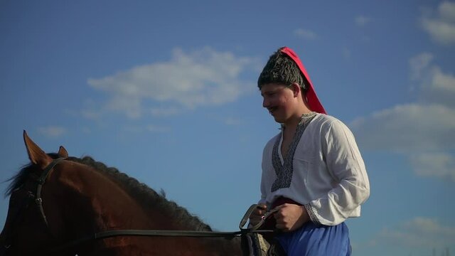 Ukrainian Cossack riding a horse in the field looks far