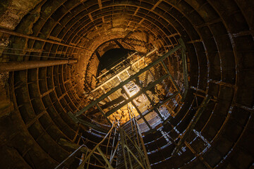Deep underground mine of cast iron tubing, bottom view. Deep subway ventilation shaft.
