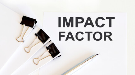 IMPACT FACTOR written on the white page with office tools