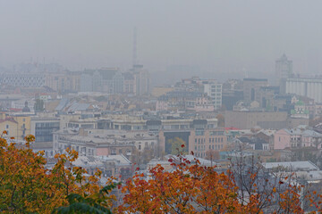 Silhouettes of buildings in the Podil district in sick fog. The rooftops of buildings. Scenic view of buildings with colorful roofs. Residential buildings in the mist. Urban landscape. Kyiv, Ukraine