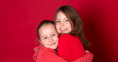 best girlfriends wearing red clothes posing and standing in front of red background