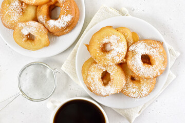 Donuts with powdered sugar on white plate