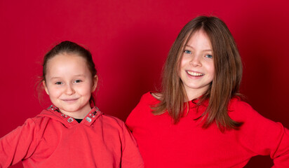 best girlfriends wearing red clothes posing and standing in front of red background