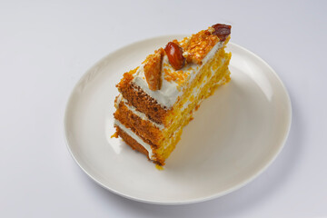 Closeup of one piece pumpkin layer cake with caramel and nut topping. Seasonal autumn cake with caramel syrup.