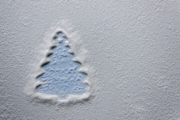 Minimalistic Christmas tree with sugar snow on a light background.