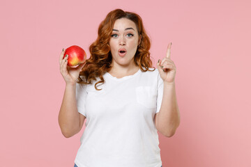 Shocked young redhead plus size body positive woman 20s in white casual t-shirt hold ripe fresh...