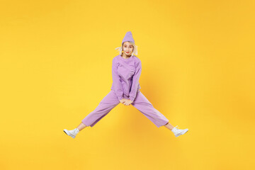 Fototapeta na wymiar Full length of young blonde excited overjoyed caucasian excited fun woman 20s bob haircut in casual basic purple suit beanie hat high jumping up isolated on yellow color background studio portrait.
