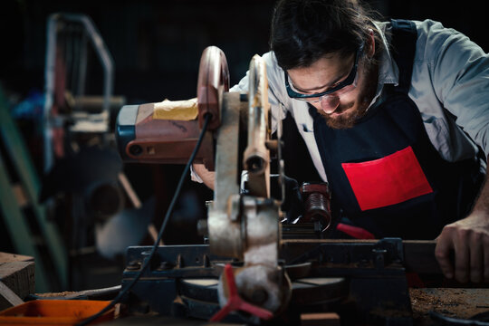 Carpenter Using Nail Gun To Nail Woodwork On Work Table In Wood Workshop