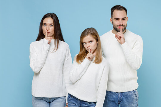 Secret Young Parents Mom Dad With Child Kid Daughter Teen Girl In Sweaters Say Hush Quiet With Finger On Lips Shhh Gesture Isolated On Blue Background Studio Portrait. Family Day Parenthood Concept.