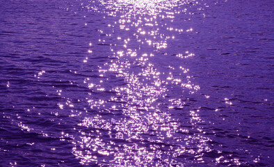 Pop art surreal style purple colored sparkling water surface with sea ripples