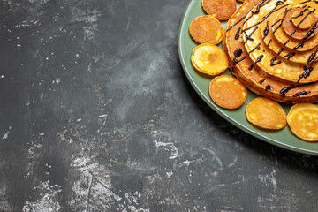 Half shot of pancake decoration on a green plate for tasty breakfast on gray background