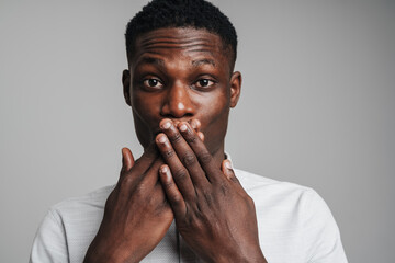 Closeup portrait of a surprised young man with hands