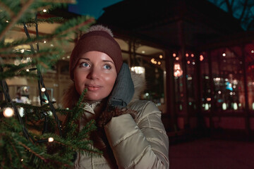 A woman in a warm hat, winter day, walking with a Christmas tree. On a walk