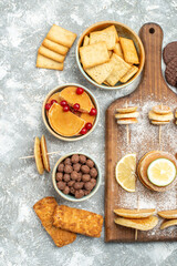 Simple pancakes with lemons on cutting board and cookies on blue background stock image
