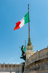 italian flag in the center of rome. a large italian flag flies on a flagpole