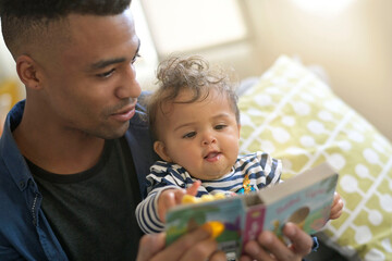young african-american man reading book story to baby girl - 399501398