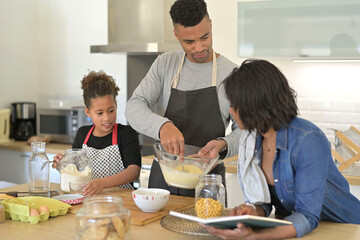 Happy family in home kitchen making homestyle american cookies