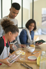 Happy family in home kitchen making homestyle american cookies