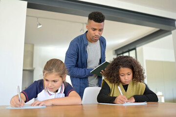 Man helping girls with school lesson