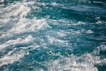Fototapeta na wymiar Sea waves with foam close-up with blurry background, used as a background or texture, soft focus