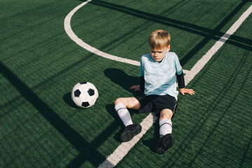 Boy player on football field with ball