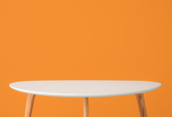 Wooden table near color wall