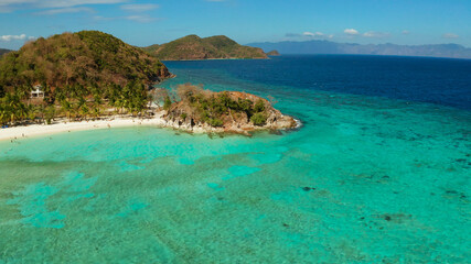 Fototapeta premium aerial seascape tourists enjoy the tropical beach. tropical island with sand beach, palm trees. Malcapuya, Philippines, Palawan. Tropical landscape with blue lagoon, coral reef