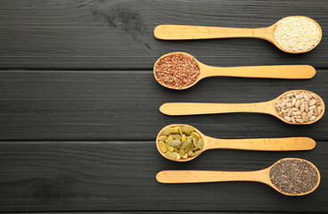 Healthy superfood: sesame, pumpkin seeds, sunflower seeds, flax seeds and chia on black. Seeds on spoon