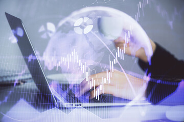 Double exposure of businesswoman hands typing on computer and forex graph hologram drawing. Financial analysis concept.