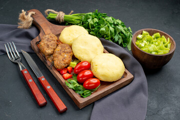 Top view of tasty cutlets chopped vegetables greens and notebook on dark background