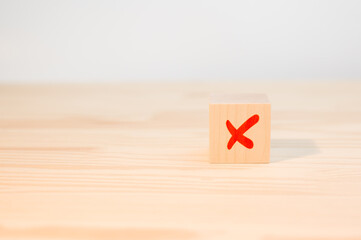 cross mark x on wooden cube. red cross sign on the edge of a wooden cube. Concept of negative...