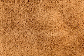 leather grunge background: an old piece of tough camel skin, with scuffs, spots, scars