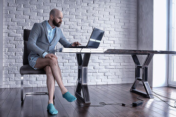 quarantined work concept, a man works at home on a computer in his underpants, funny work coronavirus pandemic meme