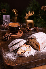 Sweet bread with dry dried fruits for Christmas. Stollen and aromatic espresso coffee with gift boxes on a wooden background. Copy space. High quality photo.