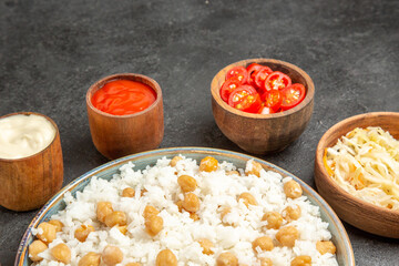 Peas and rice meal for dinner with sauerkraut salad mayonnaise and ketchup on dark background