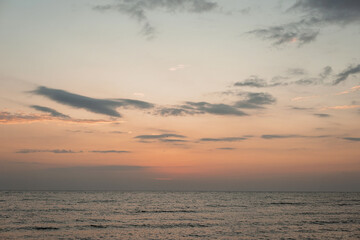 Colorful sunset on a sandy beach, waves with foam on the sand. Ocean, coast. Soft selective focus.
