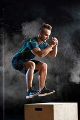 Box jump exercise young man doing functional workout at the gym