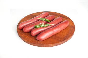 Raw meat beef sausages for grill and spicy, herbs rosemary, pepper, salt on table