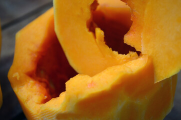 Sliced ​​orange pumpkin on a wooden board. Fresh vegetables without skin. Pieces.