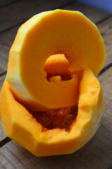 Sliced ​​orange pumpkin on a wooden board. Fresh vegetables without skin. Pieces.