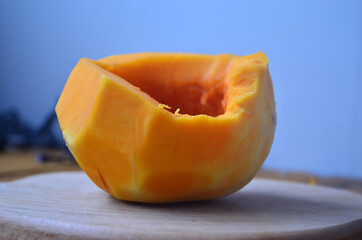 Sliced ​​orange pumpkin on a wooden board. Fresh vegetables without skin. Pieces.