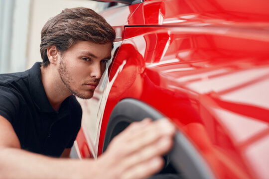 Focused man checking car before purchase