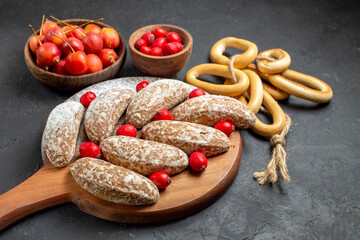 Vertical view of delicious banana cookies with fruits in bowls on dark table